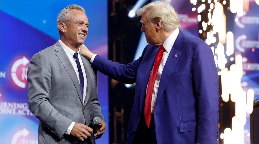 President Donald Trump and HHS Secretary Robert F. Kennedy Jr. stand together during a policy discussion, addressing upcoming health reforms and agency shakeups.