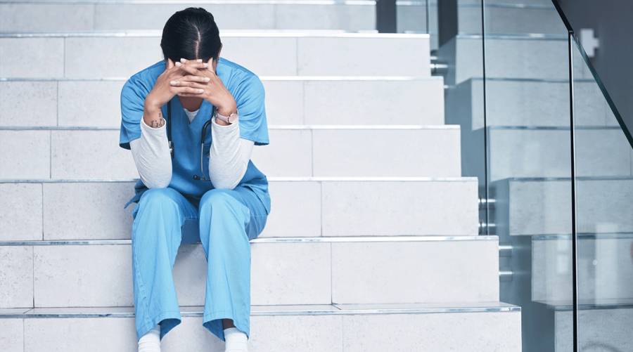 Nurse looking exhausted in hospital amid rising burnout and workplace violence